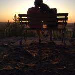 People on bench at sunset